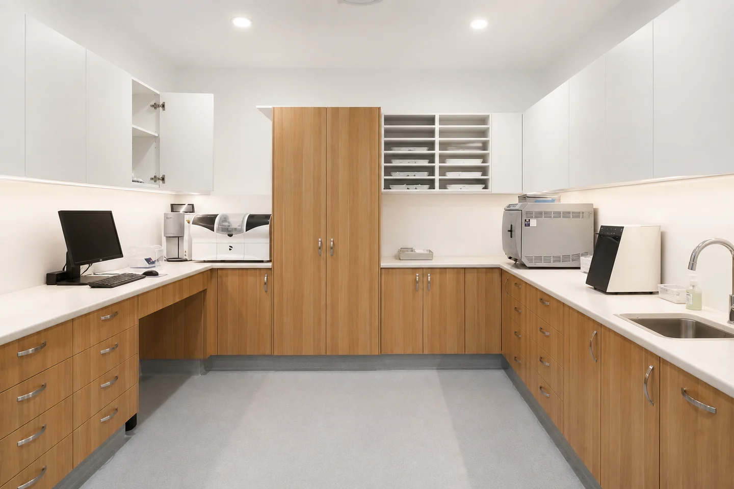 Sterilisation room with U-shaped oak cabinetry, equipment and a sink